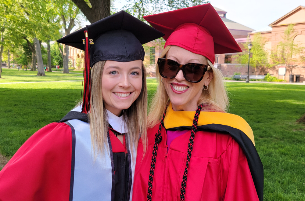 Regina Whittick, on right, and her daughter Charlotte wearing red caps and gowns at Rutgers' graduation.